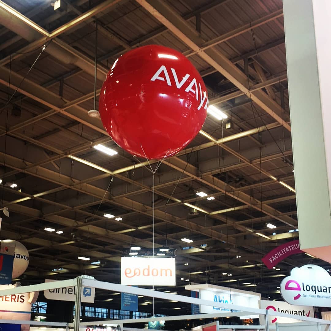 Ballon publicitaire rouge Avaya à l’hélium au salon Stratégie Clients