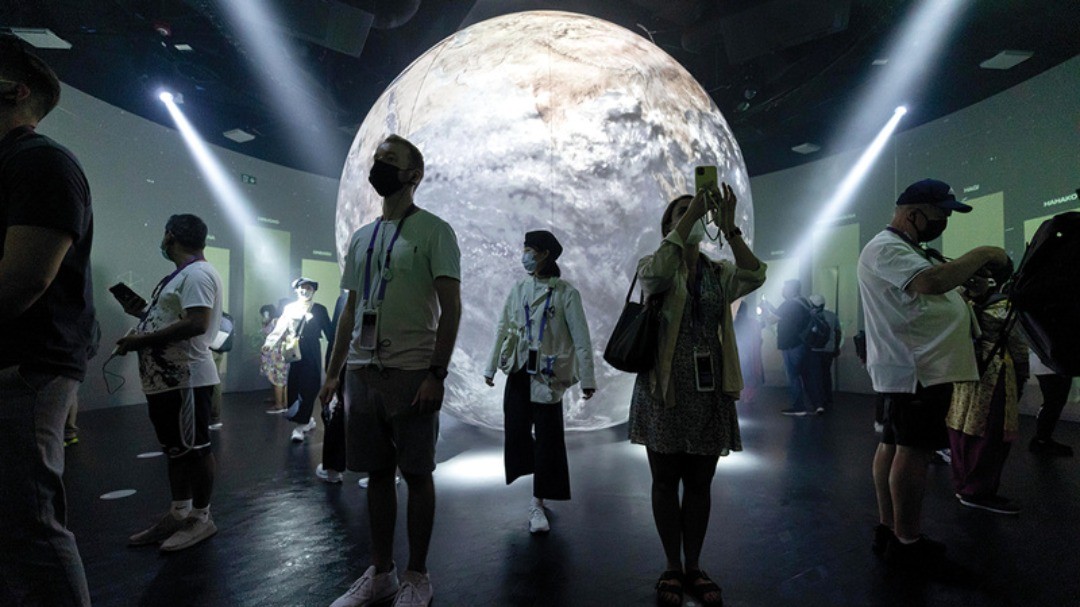 Projection lunaire sur une grande sphère au centre d’une installation immersive