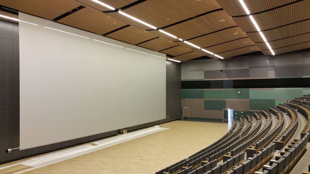 Grande toile de projection installée dans un auditorium